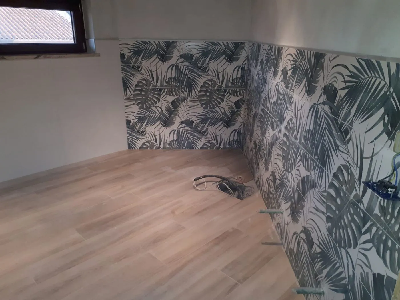 Bagno con rivestimento decorato e pavimento effetto legno